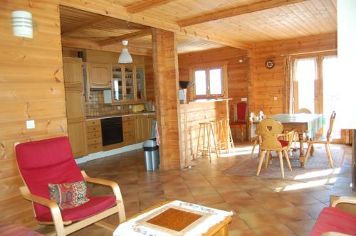 a living room with a table and chairs in a cabin at Spacieux Chalet in Les Chapelles