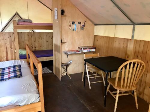 a room with a table and a bed and a desk at Sven's Basecamp Hostel in Fairbanks
