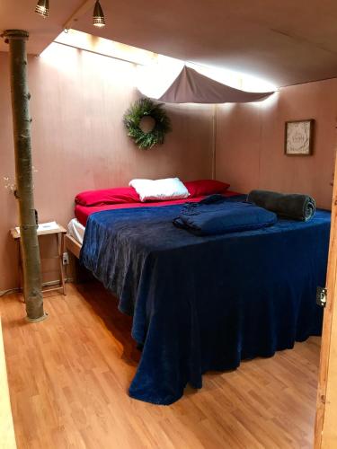 a bedroom with a bed with a blue blanket at Sven's Basecamp Hostel in Fairbanks