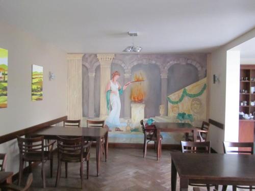 a painting of a woman on a wall in a dining room at Hotel Restaurant Hestia in Eijsden