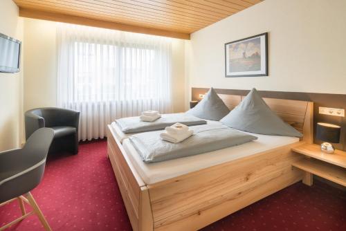 ein Schlafzimmer mit einem Bett mit zwei Handtüchern darauf in der Unterkunft Hotel Leitner in Kaufbeuren