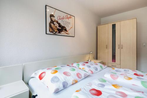 Un dormitorio con una cama y un cuadro en la pared. en Altstadt Kunstmuseum, en Düsseldorf