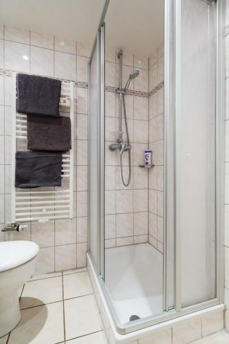 a shower with a glass door in a bathroom at Altstadt Kunstmuseum in Düsseldorf