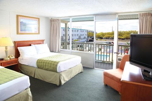 オーシャンシティにあるSeabonay Oceanfront Motelのベッド2台とバルコニーが備わるホテルルームです。