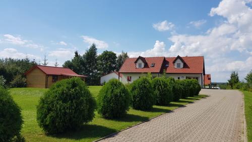 a house with a row of trees in front of it at Gościniec Mazurek in Giżycko