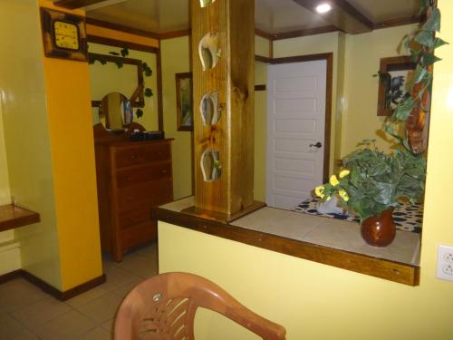 a kitchen with yellow walls and a counter with a chair at Cocopele Inn in San Ignacio