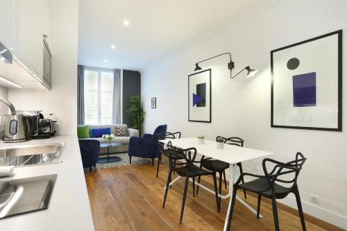 une cuisine et un salon avec une table et des chaises dans l'établissement Rent a Room - Residence Blanche, à Paris