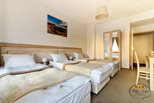 En eller flere senge i et værelse på Villa Astra - Apartments & Restaurant