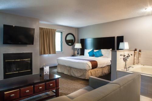 Habitación de hotel con cama y bañera en Heartland Inn Coralville, en Coralville