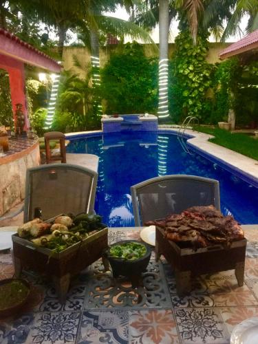 two containers of food on a table next to a pool at Hacienda Boutique B&B and Spa Solo Adultos in Cozumel