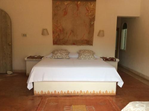 - une chambre avec un lit blanc orné d'une peinture murale dans l'établissement Caraibidamari, à Bayahibe