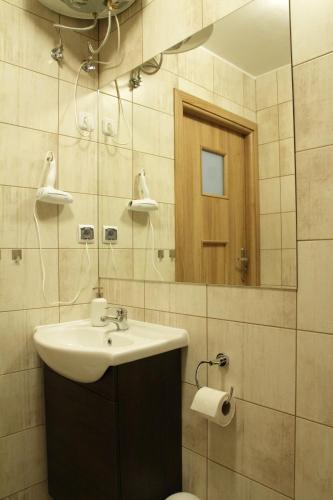 a bathroom with a sink and a mirror and a toilet at Rest- Pokoje z Łazienkami in Gdynia