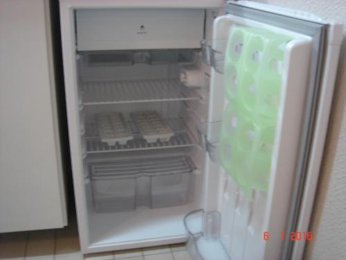 a refrigerator with its door open in a kitchen at Wall Street Flat Service in Caxias do Sul