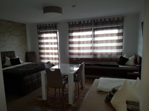 a living room with a table and a bed and a bedroom at Aparthotel Magnolia in Oberursel