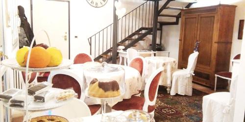 een kamer met witte tafels en stoelen en een trap bij La Maison di Bologna in Bologna