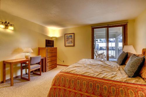 a bedroom with a bed and a table and a desk at The Plaza Condominiums by Crested Butte Mountain Resort in Mount Crested Butte