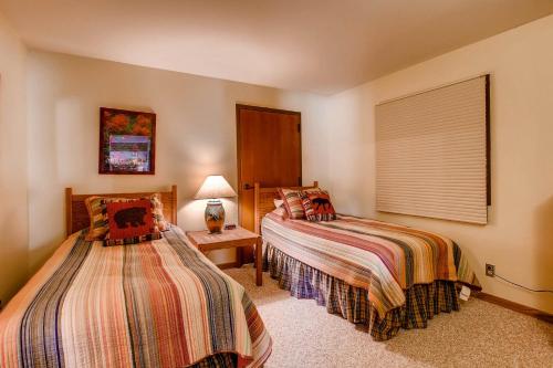 a bedroom with two beds and a lamp and a window at The Plaza Condominiums by Crested Butte Mountain Resort in Mount Crested Butte