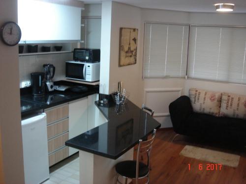 a kitchen with a black counter top in a room at Wall Street Flat Service in Caxias do Sul