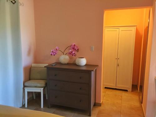 een slaapkamer met een dressoir en een stoel met bloemen erop bij La Boheme Aruba in Palm-Eagle Beach