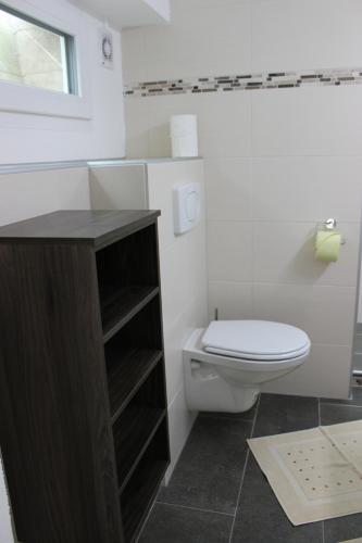 a white bathroom with a toilet and a window at Berghäusl in Tux