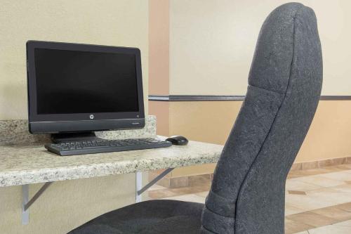 a persons leg on a desk with a computer monitor at Super 8 by Wyndham Sheboygan WI in Sheboygan