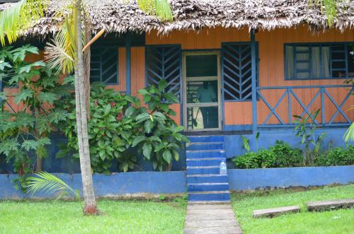 a house with a palm tree in front of it at Eware Refugio Amazonico in Puerto Nariño