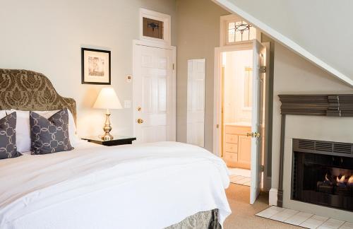 a bedroom with a fireplace and a bed at 1801 First Luxury Inn in Napa