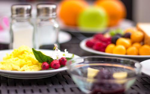a table topped with plates of food and fruit at El Patio Hostel Quito in Quito