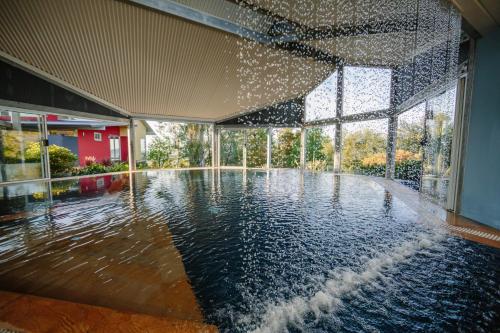 a swimming pool in a building with water pouring into it at Mt Hay Retreat in Berry