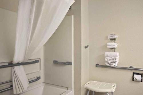 ein Bad mit einer Dusche, einem WC und Handtüchern in der Unterkunft Super 8 by Wyndham Whitewater WI in Whitewater