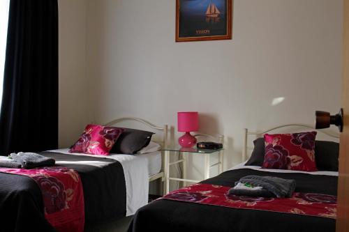 a room with two beds and a pink lamp at Cape Jervis Holiday Units in Cape Jervis