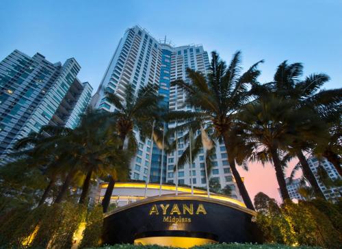 a group of palm trees and a building with a sign at AYANA Midplaza JAKARTA in Jakarta