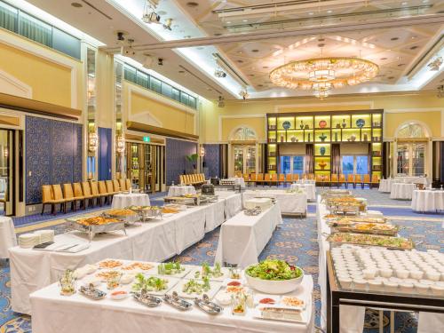 a dining room with tables filled with food at Hotel Crown Palais Kobe in Kobe