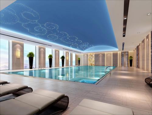 a large swimming pool in a building with a blue ceiling at Wanda Realm Taizhou in Taizhou
