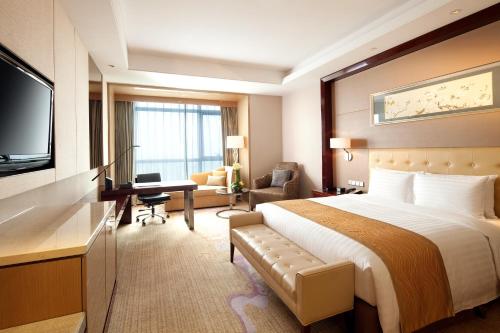 a hotel room with a bed and a television at Wanda Realm Taizhou in Taizhou