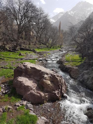 a river with a rock in the middle at Dar Amadine in Imlil
