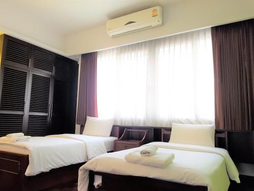 a hotel room with two beds and a window at P.T. Court in Bangkok