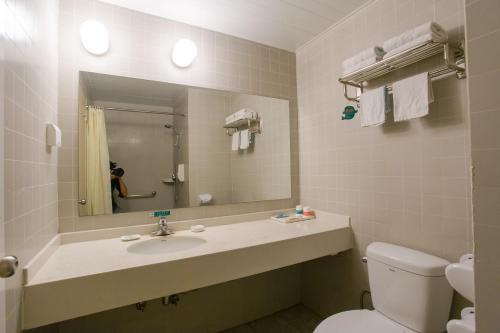 a bathroom with a sink and a toilet and a mirror at Jinjiang Inn Beijing East Lianshi Road in Beijing