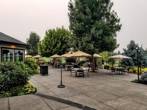 a patio with tables and chairs and umbrellas at Resort at Eagle Point Golf Club Lodging in Medford