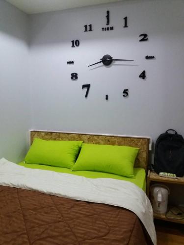 a bedroom with a bed with a clock on the wall at Heuan Na Khee in Udon Thani