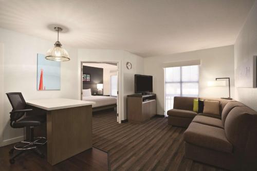 a living room with a couch and a desk in a room at Hyatt House Pleasant Hill in Pleasant Hill