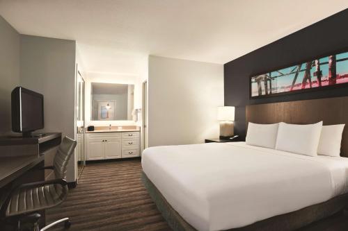 a hotel room with a large bed and a television at Hyatt House Pleasant Hill in Pleasant Hill
