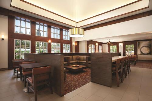 a restaurant with a bar and tables and chairs at Hyatt House Pleasant Hill in Pleasant Hill