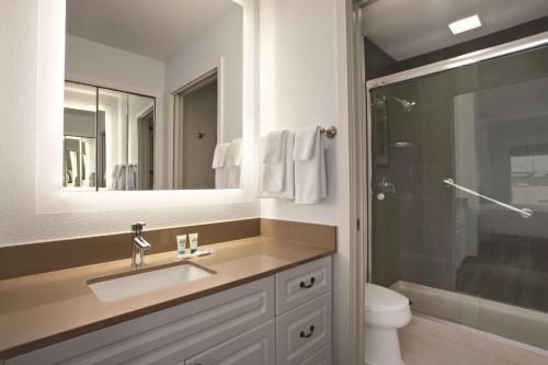 W łazience znajduje się umywalka, toaleta i lustro. w obiekcie Hyatt House Pleasant Hill w mieście Pleasant Hill