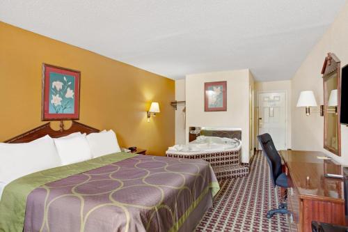 a hotel room with a bed and a desk at Super 8 by Wyndham Forrest City AR in Forrest City