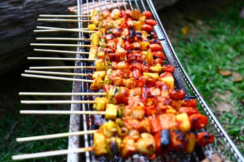 een rij spiesjes die eten koken op een grill bij Baan Khaosok Resort in Khao Sok