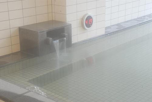 a water fountain in a tiled bathroom stall at Renaissance Tanagura in Shirakawa
