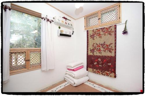 a room with a window and a pile of towels at Dowon Guesthouse in Jeonju