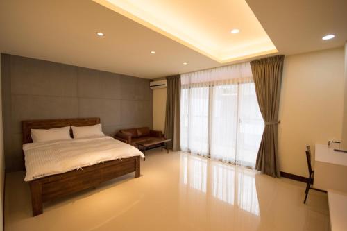 1 dormitorio con cama y ventana en Shamuni B&B, en Magong