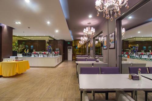 a restaurant with tables and chairs and a chandelier at Jinjiang Inn Beijing Gucheng North Road in Beijing